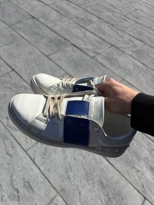 Valentino vita sneakers med blå detalj - Valentino skor som inte längre kommer till användning. Priset är diskuterbart och satt pga ingen garanti på äkthet samt ingen box eller kvitto Storlek 43 