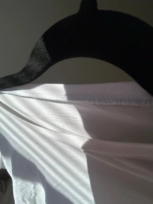 Intimissmi t-shirt i bomull - Klassisk vit t-shirt med rund hals och korta ärmar. Tillverkad i mjuk bomull som känns skön mot huden. Perfekt att matcha med jeans eller shorts för en enkel och clean look🥂