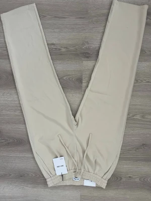 Beige mjukisbyxor från Only & Sons - Snygga beige mjukisbyxor från Only & Sons med resår i midjan och dragsko för skön passform. Tillverkade i mjukt material som känns bekvämt hela dagen. Perfekta för en avslappnad stil och har raka ben. Helt nya aldrig använda 10/10 skick