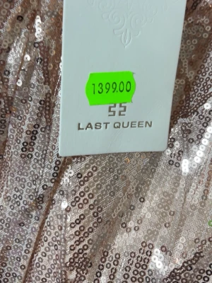 Glittrig långklänning Last Queen - Supersnygg långklänning från Last Queen i ljus champagnefärg med glittriga paljetter. Klänningen har smala axelband, figurnära passform och ett elegant mönster av paljetter över hela tyget. Perfekt för bal eller festliga tillfällen. Storlek S men den passar inte M också(stretchig material) prislapp på, säljs pågrund av att det inte passar, helt ny
