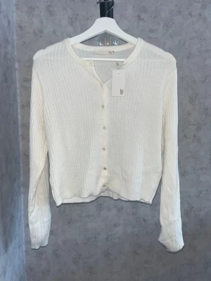 Vit ribbad kofta - Snygg vit ribbad kofta från Lager 157 med knappar. Långärmad modell i mjukt, stretchigt material som passar perfekt till lager-på-lager🫰🏻