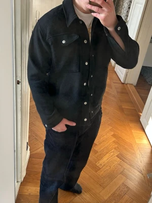 Svart overshirt - Stilren svart overshirt från Valient med klassisk krage och tryckknappar. Två stora bröstfickor med lock och knapp. Storlek S men passar M.