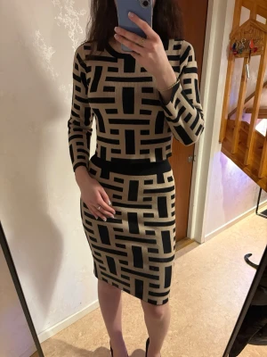 Beige och svart set med grafiskt mönster - Säljer ett snyggt matchande set i stickat material: croppad långärmad tröja och figurnära kjol. Beige/nude med svart grafiskt mönster som ger en stilren och lyxig look. Snyggt både som set eller var för sig – passar till vardag, brunch, uteservering eller semester ☀️ • Tröja + kjol • Beige/nude & svart • Figurnära passform • Mjukt, stretchigt material • Passar ca XS/S Använt få gånger och i fint skick. Svår modell att hitta nu. Kan skickas eller mötas upp.