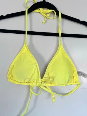 Gul triangel-bikini topp, stl M - nyskick - En gul triangel-bikinitopp i storlek M. Säljer pga av att den inte används. Använd en gång 💛
