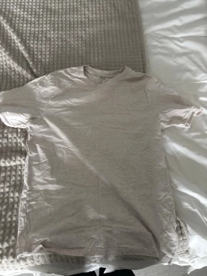 Ljusbeige basic t-shirt - En enkel och stilren ljusbeige t-shirt i mjuk bomull. Klassisk passform med rund hals och korta ärmar, perfekt till alla typer av outfits. Passar dig som gillar minimalistisk och clean stil.