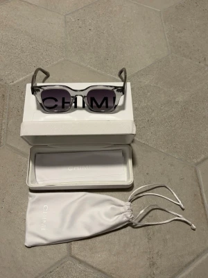 CHIMI solglasögon  - Säljer ett par stilrena solglasögon från CHIMI med fyrkantig form och mörka glas. Kommer med originalfodral och tygpåse. Perfekta för dig som vill ha en clean och modern look. Hör av dig vid minsta intresse! ⭐️