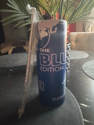 Red Bull The Blue Edition termosmugg 0.6L - Stor blå termosmugg med Red Bull, The Blue Edition print. Burken är cylindrisk och tillverkad i metall, med vit och blå design samt Red Bulls logga. Volymen är 20oz (ca 0.6L). Håller värme & kyla extremt länge även i strålande sol!