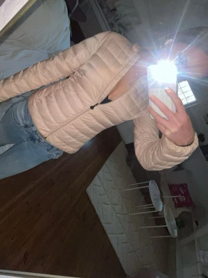 Ljusrosa dunjacka från Moncler - Säljer en ljusrosa dunjacka från Moncler med figurnära passform och dragkedja framtill. Storleken är orginalt 14år/164 men passar Xs-S  Jackan har det klassiska Moncler-logotypen på ärmen och är gås dun. Perfekt för våren och sommaren. Pris kan självklart diskuteras!