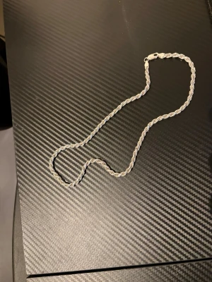 Cordell kedja ÄKTA Silver - Säljer ett stilrent halsband i silver med cordell kedja. Halsbandet har en klassisk design och passar perfekt till att lyfta vilken outfit som helst. Materialet är silver med en snygg glansig finish. Finns stämpel 925 den är 50cm lång