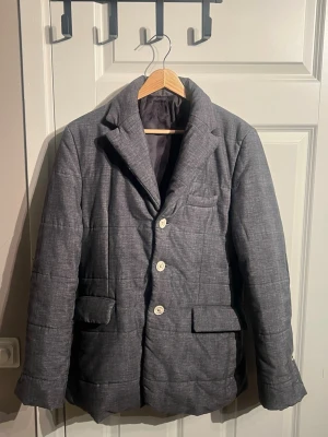 Grå vadderad kavaj med vita knappar - Köpt i New York för 15 årsen riktig vintage och säljs för endast 199 och köpte runt 6000 