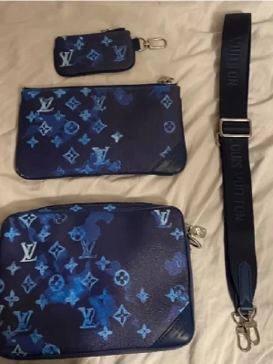 Blå Louis Vuitton handväska set - Säljer ett set med blå handväskor från Louis Vuitton med ikoniskt monogrammönster i olika blå nyanser. Setet inkluderar tre väskor i olika storlekar och en justerbar axelrem med Louis Vuitton-tryck. Väskorna är tillverkade i slätt läder med silverfärgade detaljer. Obs kan gå ner i pris 