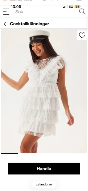 Vit spetsklänning med volanger - Superfin vit kort klänning i spets med flera lager volanger och v-ringning. Klänningen har korta ärmar och transparenta detaljer upptill. Perfekt för student eller sommarens alla tillfällen.