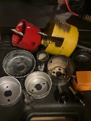 Blandade hålsågar och borrhuvuden HSS mm - Säljer ett gäng hålsågar i olika storlekar och färger, bland annat röda, gula och metallfärgade. Perfekt för dig som gillar att fixa hemma eller behöver extra verktyg till borrmaskinen. Inkluderar även några borrhuvuden och en orange förpackning.