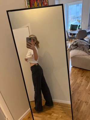 Svarta vida jeans  - Säljer ett par svarta jeans raka och vida ben. Jeansen har klassisk femficksdesign och knappgylf. Perfekta för en avslappnad och trendig look. Materialet är denim i bomull. Passar dig som gillar loose fit och streetstyle. Skulle säga att dom är S/M passar mig som är 175