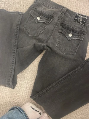 Grå True Religion jeans med fickdetaljer - Jag säljer ett par nya true religon jeans, endast använda 1 gång. Inga fläckar osv. Pris kan diskuteras 
