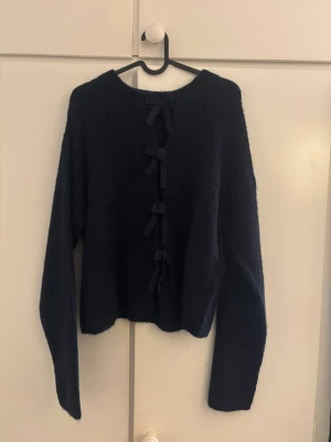 Mörkblå stickad tröja med rosetter - Mysig mörkblå stickad tröja med rosetter😍Tröjan är från Gina Young och är nästan helt oanvänd!