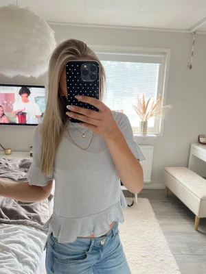 Grå glittrig stickad topp - Stickad topp med volanger som är lite silver glittrig, fint skick och kommer från hm💗