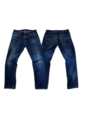 Blå jeans från Nudie Jeans - Säljer ett par klassiska blå jeans från Nudie Jeans med snygg slitning och raka ben. Jeansen har fem fickor, kontrastsömmar och en mörk tvätt med ljusare partier. Perfekta för en avslappnad och trendig look. Lagade i bland annat fickorna så inga hål finns