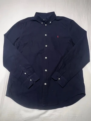 Ralph Lauren skjorta - En riktigt fin skjorta ifrån Ralph Lauren! Den är i ett mycket fint skick och i barnstorlek XL (18 - 20) vilket motsvarar ca herrstorlek XS eller S!👌 Nypris är ca 1700kr!💰 Tveka inte på att skriva om du skulle vara i behov av fler bilder på plagget!📸 Skriv vid minsta lilla fundering!🖋️ Fraktar alltid senast dagen efter eller samma dag som beställning!📦