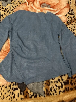 Blå asymmetrisk blus med långa ärmar - Snygg blå blus med långärmad design och unik asymmetrisk nederkant. Tillverkad i ett tunt, lätt tyg som ger en avslappnad men ändå stilren look. Perfekt för dig som gillar minimalistisk stil med en twist. Helt oanvänd och i nyskickZ 