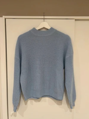 Ljusblå stickad tröja - Mysig ljusblå stickad tröja med ribbad struktur och rund hals. 