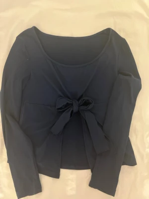 Mörkblå topp med knyt från SHEIN  - Trendig mörkblå långärmad topp från SHEIN med snygg knyt-detalj framtill. Tillverkad i mjuk och stretchig polyesterblandning som sitter bekvämt på kroppen. Perfekt för att lyfta vilken outfit som helst med en enkel men chic look. 💙