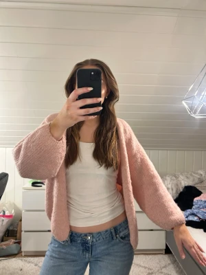 Ljusrosa fluffig kofta från Lindex!  - Säljer denna supermysiga trendiga ljusrosa kofta med lös passform och ballongärmar från Lindex! Koftan är stickad i ett fluffigt material och har ingen knäppning framtill. Som man kan se på bilderna är de väldigt mycket nopprar över hela koftan annars inga defekter!☺️