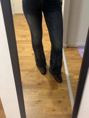 Mörkblå bootcut jeans cheap monday  - Snygga mörkblå bootcut jeans med klassisk femficksdesign och lätt utsvängda ben. Jeansen har en tidlös tvätt och sitter tajt över låren för en schysst siluett. Perfekta till sneakers eller boots och passar till många olika stilar.