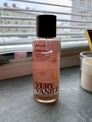 Pink Very Vanilla Body Mist - Fräsch body mist från Pink i doften Very Vanilla. Flaskan är genomskinlig med rosa toner och svart lock. Doften har inslag av vanilj, kanel och socker, perfekt för dig som gillar söta och varma dofter. Innehåller eteriska oljor och rymmer 250 ml. Se bild hur mycket som finns kvar 