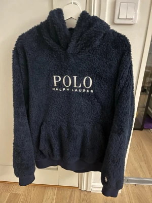 Mörkblå teddyhoodie Polo Ralph Lauren - Mörkblå hoodie med fluffigt tyg. Mycket gott skick och är perfekt till lite kallare dagar när man bara vill softa hemma i soffan. Bara att kontakta vid intresse!