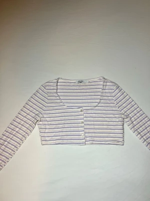 NA KD - Crop top  - Ribbad crop top/kofta i mycket bra skick, från NA KD i storlek L🌸                                         -Knappar framtill                                                  -93% Viscose, 7% elastane                                          -Axelbredd: 40cm / Längd: 33cm 