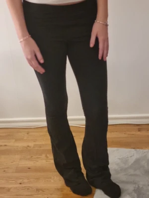 Svarta bootcut leggings - Säljer ett par svarta leggings med bootcut-modell och hög midja. De är stretchiga och sitter tajt över låren men har utsvängda ben nertill. Perfekta till sneakers eller boots och superbekväma att ha på sig hela dagen. Lappen är bort klippt.