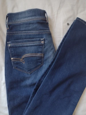 Vintage bootcit jeans  - Vintage bootcit jeans med silver och guld design på fickorna där bak. Medel hög midja med en "använd" look över jeansen. 