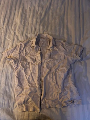 Beige dressman kortärmad skjorta äkta linne - Snygg beige skjorta med korta ärmar och två bröstfickor med lock. Skjortan har klassisk krage och knäppning framtill. Perfekt för en avslappnad och stilren look.