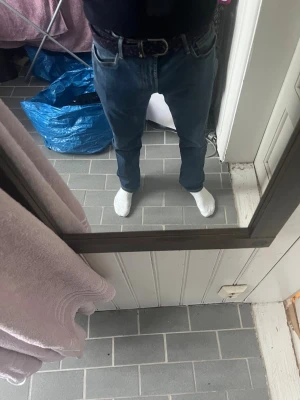 Mörkblå jeans från Armani - Säljer ett par mörkblå jeans från Armani med klassisk femficksmodell och raka ben. Jeansen har snygga kontrastsömmar och ett diskret logomärke på bakfickan. Perfekta för dig som gillar stilrena och tidlösa jeans.