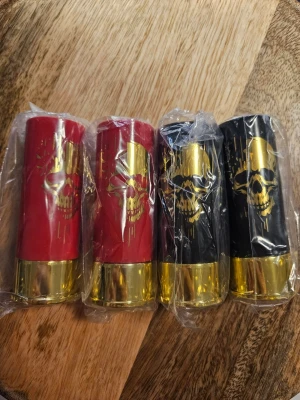 Coola dödskalle-skottglas i plast - Fyra skottglas i plast formade som patroner, två röda och två svarta med guldfärgade bottnar och dödskallemotiv i guld. Perfekta för fest eller som rolig present till någon som gillar unika glas.