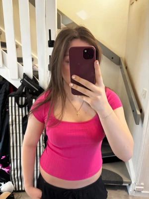 Rosa ribbad croppad topp  - Snygg croppad topp från Esprit i en stark rosa färg. Toppen har korta ärmar, ribbad struktur och en fyrkantig urringning. Perfekt för dig som gillar en trendig och bekväm stil.💖