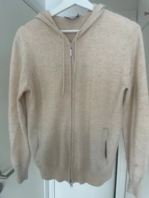 Beige cahsmire/ merinoull zip kofta - Säljer denna snygga beige cahsmire och merinoull zip koftan. Koftan är i ett fint sick men lite nopprig. Storlek: xs
