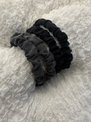 3-pack scrunchies svart & grå - Diadem i mjukt tyg, två svarta och en mörkgrå. De har en klassisk rynkad design och passar perfekt för att sätta upp håret på ett snyggt och enkelt sätt. Materialet känns bekvämt och elastiskt🩷(sälj styckvis!!)