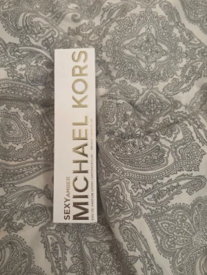 Michael Kors Sexy Amber parfym - Michael Kors Sexy Amber parfym i elegant vit och guldig förpackning. Doften är en eau de parfum och kommer i en rektangulär kartong med stilren design. Perfekt för dig som gillar lyxiga och moderna dofter. För fler bilder/information skriv gärna, priset kan justeras 🤗❤️ (köps utomlands)