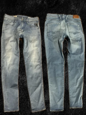 Ljusblå jeans från Replay - W32 L30Snygga ljusblå jeans från Replay med klassisk femficksmodell och raka ben. Jeansen har slitningar och tvättade detaljer för en trendig look. Bakfickorna har dekorativa sömmar