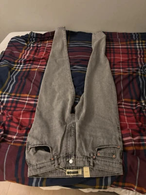 Grå jeans från Woodbird - Snygga grå jeans från Woodbird i modellen Leroy Ash. Jeansen har klassisk femficksdesign, raka ben och är tillverkade i ett slitstarkt denimtyg. Perfekta för dig som gillar en stilren och avslappnad look.