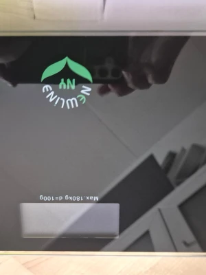 Digital våg från Newline - Elektronisk våg från Newlina i svart glas med digital display. Modern design med grönt och vitt logotryck på ovansidan. Perfekt för att väga upp till 180 kg, smidig att använda i hemmet. Platt och stilren form som passar i alla rum.