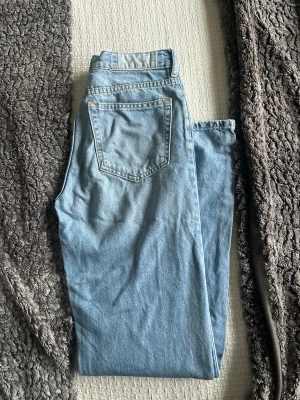 Ljusblå jeans från KARVE - Säljer ett par ljusblå jeans från KARVE med klassisk femficksdesign och dragkedjegylf. Jeansen har raka ben och är tillverkade i denim. Perfekta för en avslappnad och trendig look.