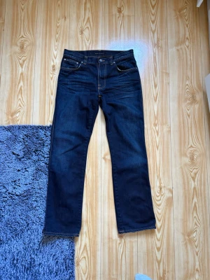 Nudie jeans straight/Bootcut - Snygga mörkblå jeans från Nudie med straight/bootcut passform och klassiska fem fickor. Storlek 33/32 men W passar mer som 32/31. Nyskick använd max 2-3 gånger. Nypris-2500kr mitt pris-899kr. Pris kan diskuteras vid snabba affärer. Jag har mått så bara att höra av sig