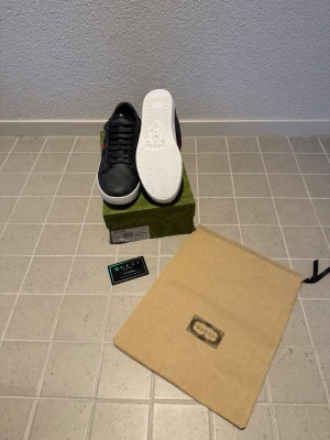 Gucci Ace skor - Helt nya Gucci Ace skor i svart läder som är perfekt till nädtan alla stilar. Dom är jätte fina och perfekt till sommaren. Boxen är lite sönder sista bilderna 