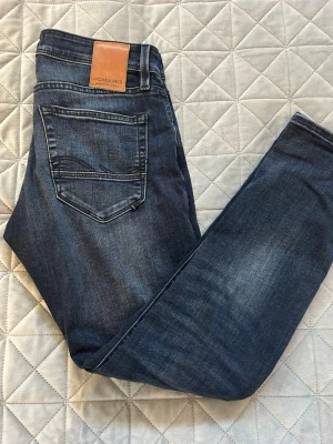 Mörkblå jeans från Jack & Jones - Säljer ett par jeans från Jack & Jones i mörkblå färg med toning. Dom är i helt nytt skick. Vid en snabb affär kan man såklart pruta. Hör av er vi funderingar!