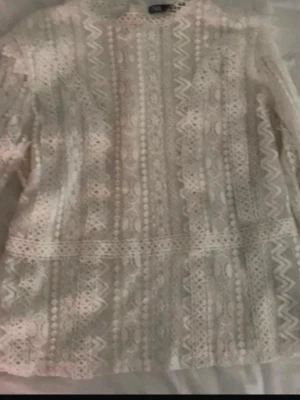 Vit spetsblus från Zara - Superfin vit blus från Zara i spets med snyggt mönster och långärmad design. Blusen har genomgående spetsdetaljer och en rak passform som ger en trendig och fräsch look. Storlek S. 🤗