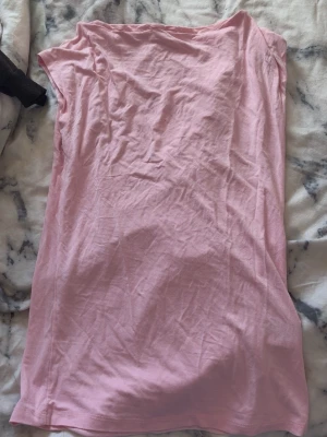 Ljusrosa ärmlös topp - Snygg ljusrosa topp i mjukt bomullsmaterial. Modellen är ärmlös och har en enkel, rak passform som gör den lätt att styla till olika looks. 