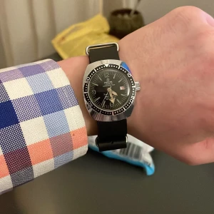 Mortima dykarklocka - vintage diver watch - Svensk klocka Mortima från 70/80 talet. Klockan är i bra skick, och riktigt läcker. Den är även manuell. Jag har bytt ut originalarmbandet - men den tillkommer vid köp. Uret är ca 35mm. Kolla sista bilden för precisa mått!